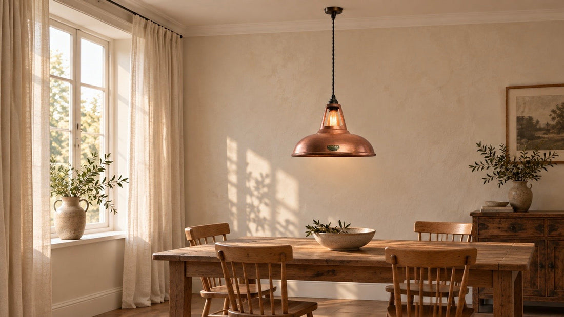 Cawston XL antique copper pendant centred above an oak dining table in a warm, neutral room with linen curtains.