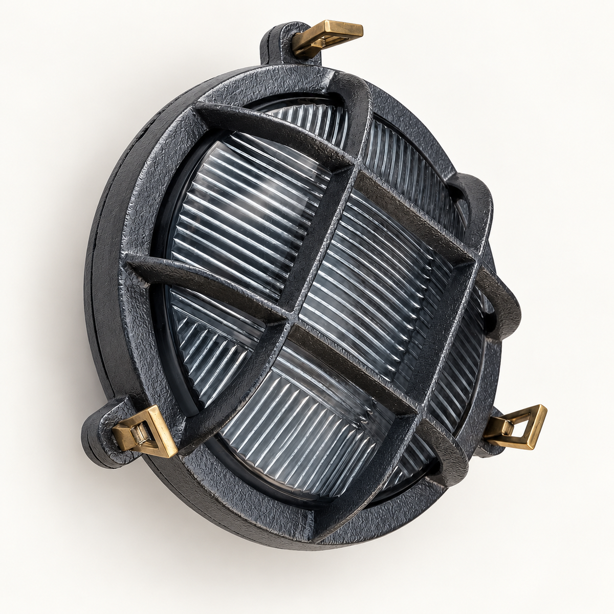 A round outdoor light fixture with a dark textured metal frame, a protective wire grid over a ribbed glass panel, and four brass mounting brackets, shown against a plain off-white background.