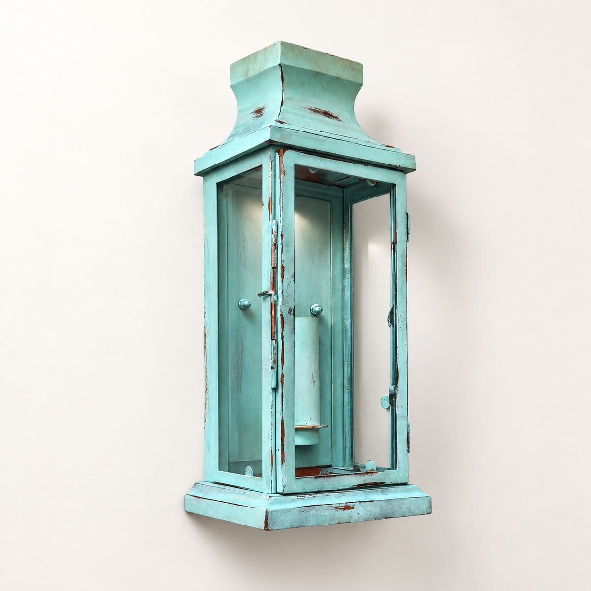 A distressed turquoise blue wooden lantern wall sconce with a weathered, shiplap-style finish and small silver knobs, mounted on a plain off-white wall.