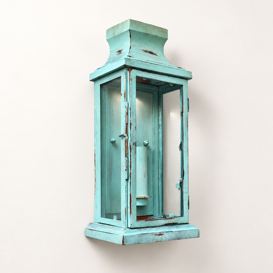 A distressed turquoise blue wooden lantern wall sconce with a weathered, shiplap-style finish and small silver knobs, mounted on a plain off-white wall.