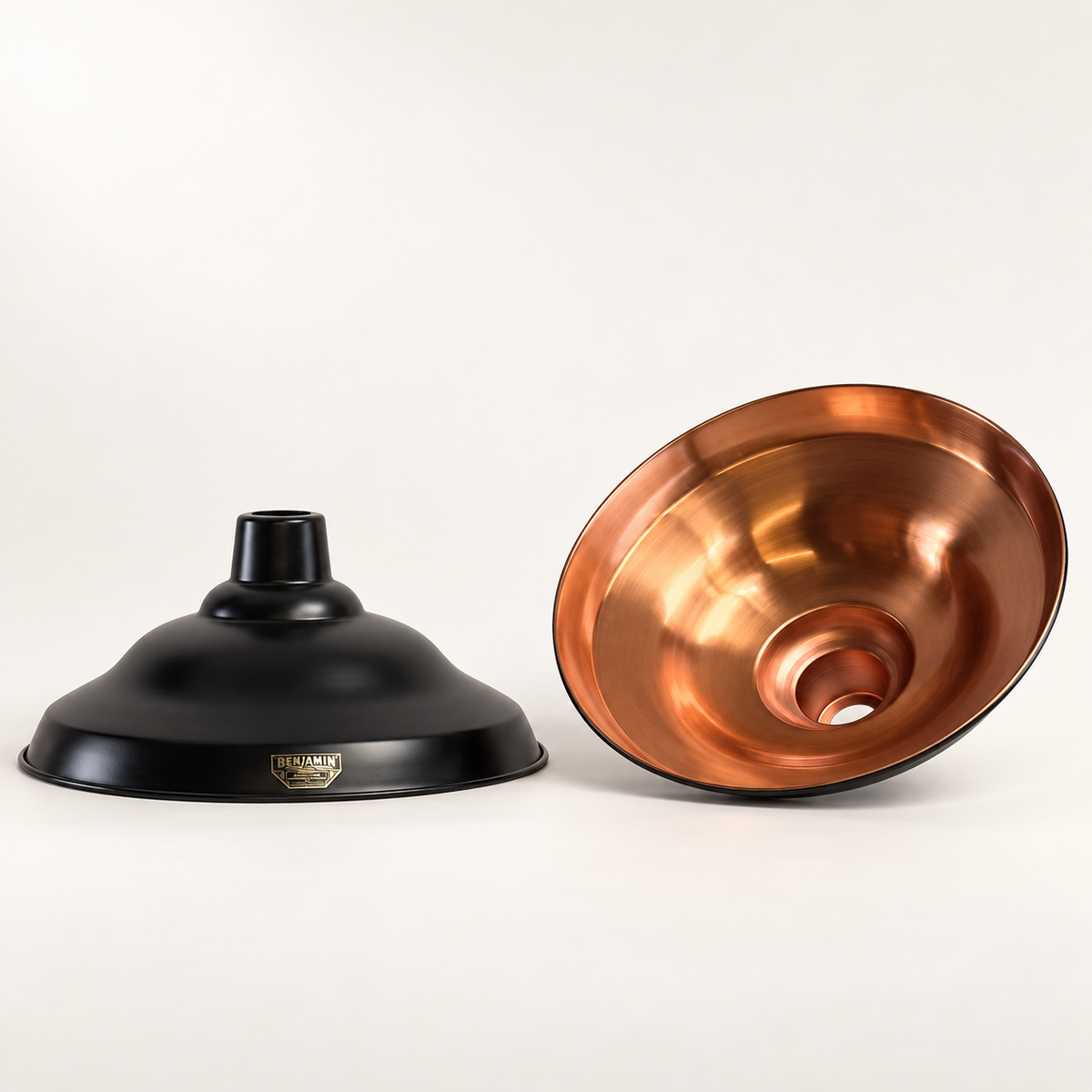 Image of the outer and inner of the lampshade, featuring a matte black metal dome shade on the left and a polished copper-toned metal bowl on the right, displayed on a clean off-white background.