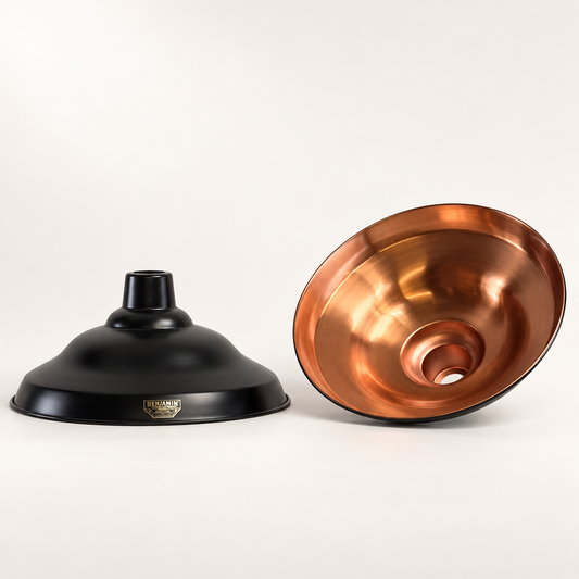 Image of the outer and inner of the lampshade, featuring a matte black metal dome shade on the left and a polished copper-toned metal bowl on the right, displayed on a clean off-white background.