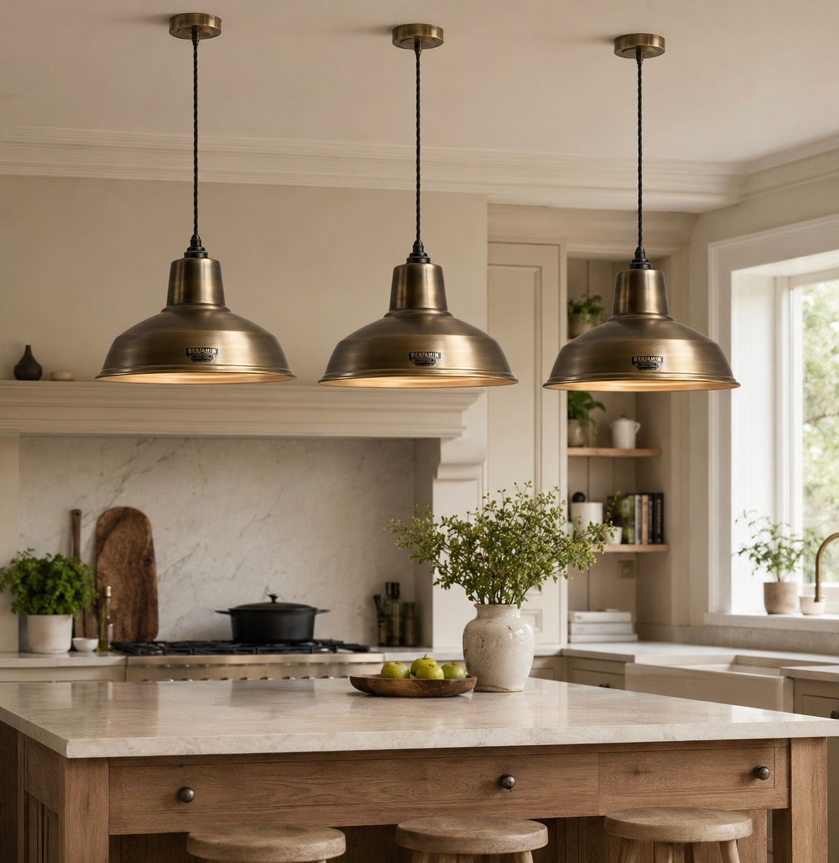 Three antique brass pendant lights above a kitchen island