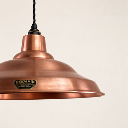 A copper dome pendant light from the brand Benjamin, featuring a black hanging cord and a black metal top fitting, shown against a plain off-white background.