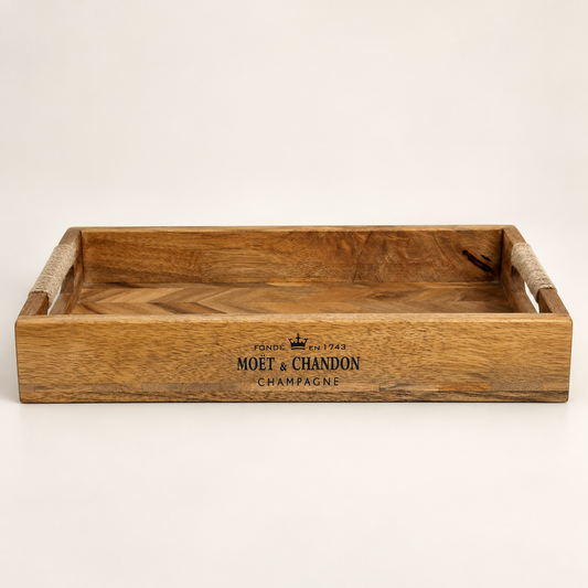 A rectangular wooden serving tray with woven rope handles and a Moet & Chandon Champagne logo printed on the front, set against a plain light background.