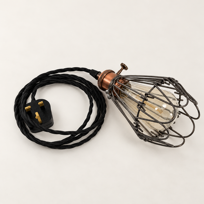 Hemsby raw steel cage lamp laid beside its coiled black fabric cable and UK three-pin plug