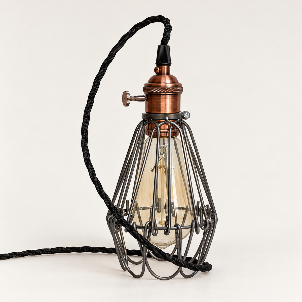 Hemsby raw steel cage table lamp with copper finish holder and black twisted fabric cable, bulb off