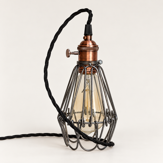 Hemsby raw steel cage table lamp with copper finish holder and black twisted fabric cable, bulb off