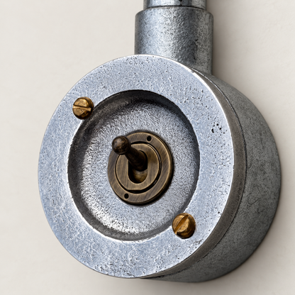 1-gang raw metal round conduit toggle light switch, studio close-up of the controls and finish.