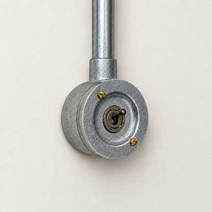 1-gang raw metal round conduit toggle light switch, front studio view.